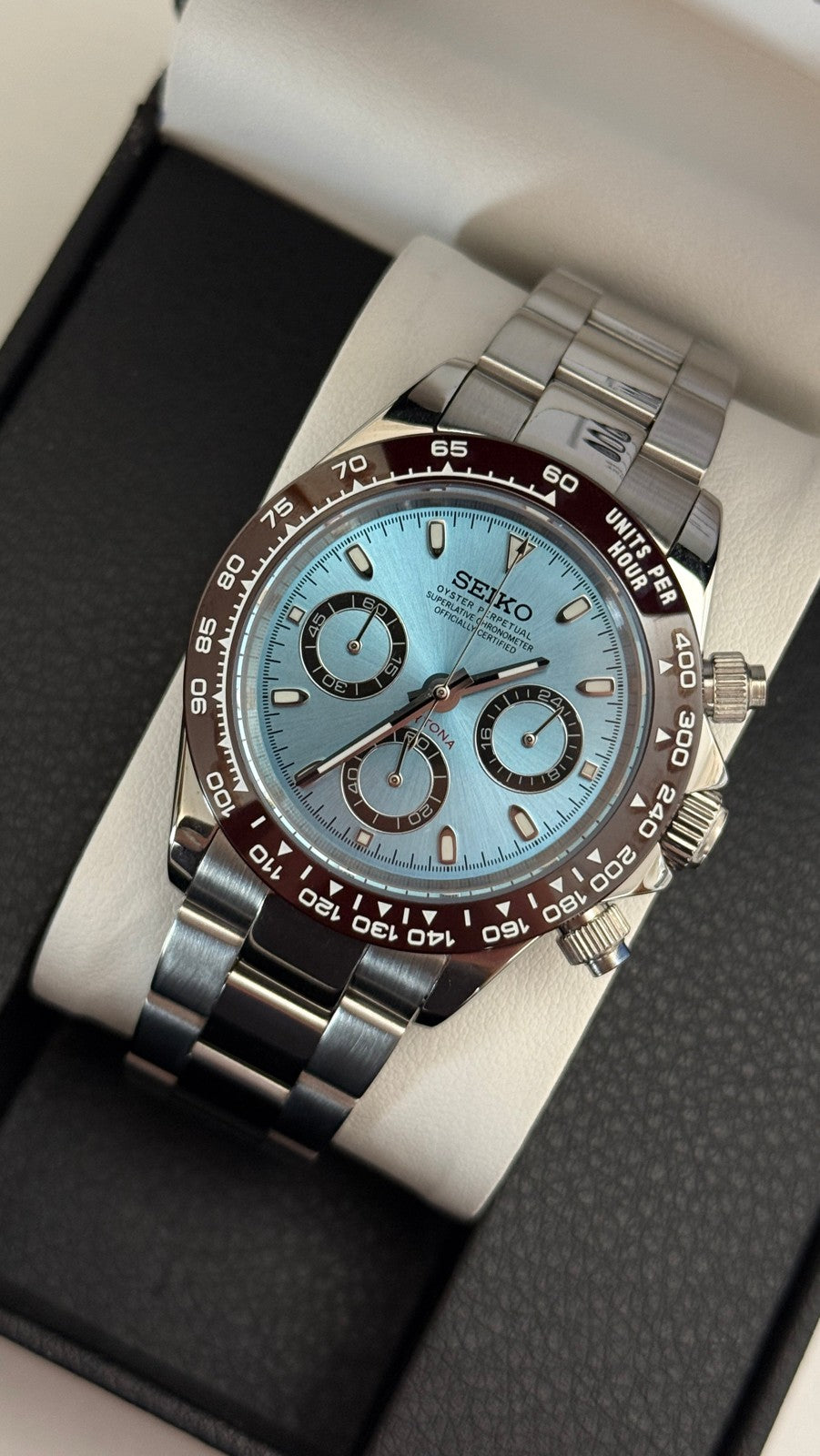 Daytona (Ice Blue) Seiko VK63 meca-quartz chronograph mod watch. A slightly angled full watch shot showing a light blue dial and brown bezel on a silver metal bracelet.