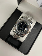 Datejust (Black Roman) Seiko NH35 automatic mod watch. A black dial watch with a silver fluted bezel and jubilee bracelet inside a box in a high angle shot.