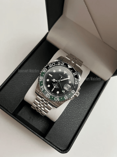 GMT (Sprite) Seiko NH34 GMT automatic mod watch. A full watch with a black dial and a black bezel on a jubilee bracelet inside a watch box.
