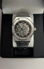 Royal Oak (Skeleton) Seiko NH70 skeleton automatic mod watch. A full watch shot shows a silver skeleton dial with a silver bezel and a silver metal link bracelet.