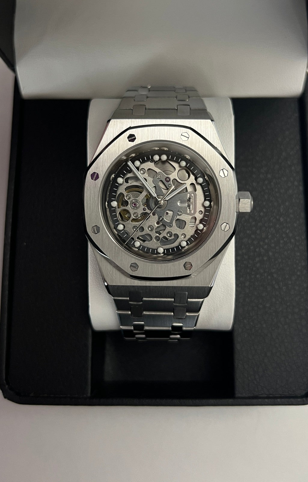 Royal Oak (Skeleton) Seiko NH70 skeleton automatic mod watch. A full watch shot shows a silver skeleton dial with a silver bezel and a silver metal link bracelet.