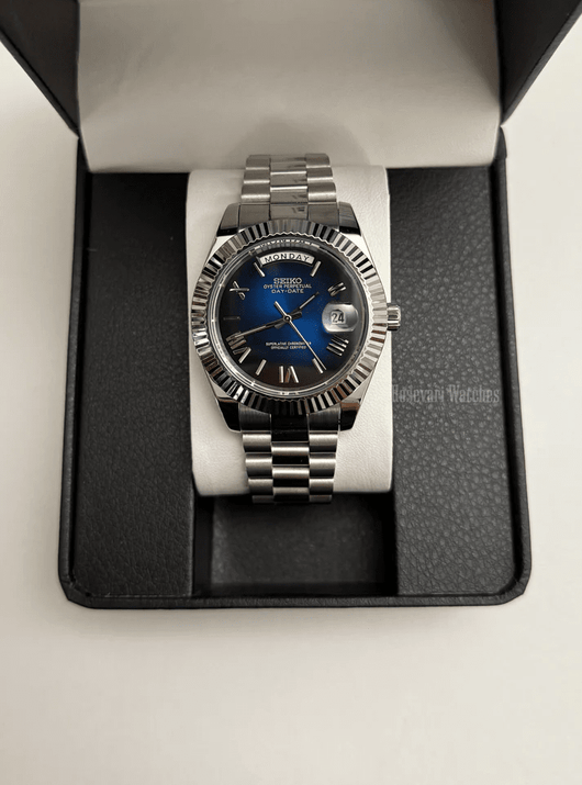 Day-Date (Blue Roman) Japanese automatic mod watch. A watch in a box with a blue dial and silver fluted bezel on a silver metal bracelet.
