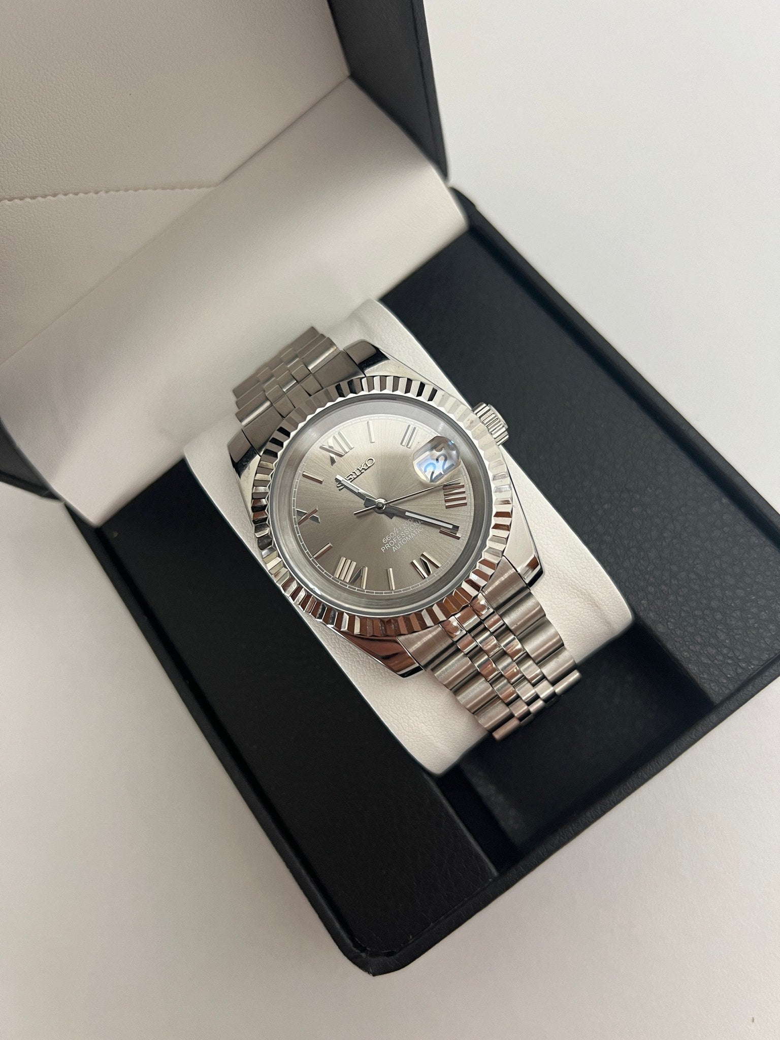 Datejust (Grey Roman) Seiko NH35 automatic mod watch. A grey dial watch with a silver fluted bezel and a metal jubilee bracelet inside an open watch box.