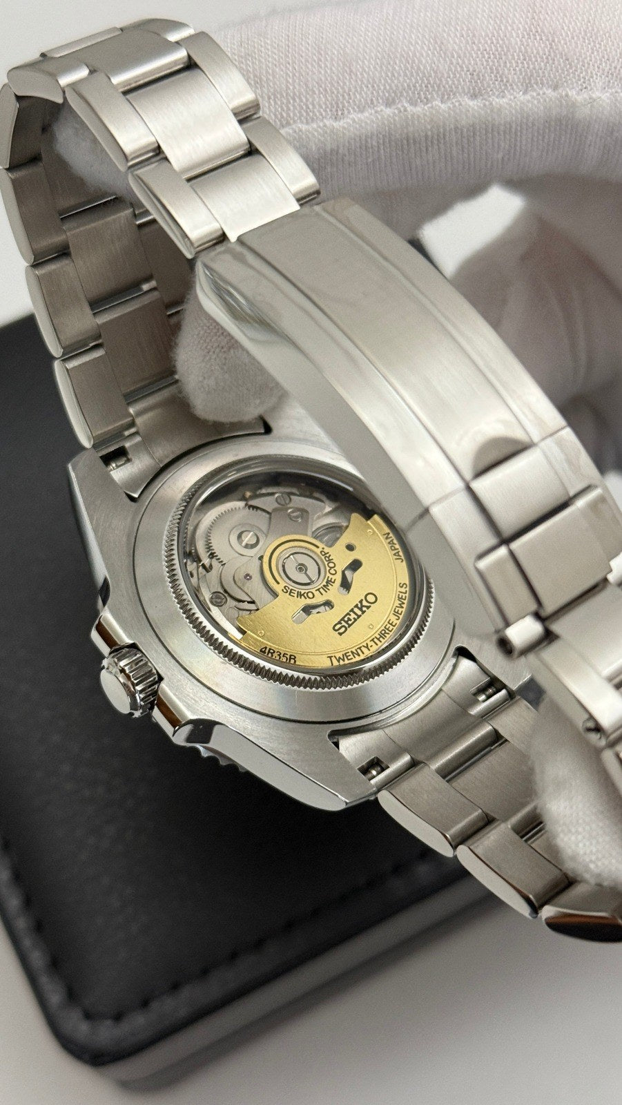 Submariner (Blue) Seiko NH35 automatic mod watch. A caseback view showing the internal mechanical movement of a watch with a silver metal link bracelet.
