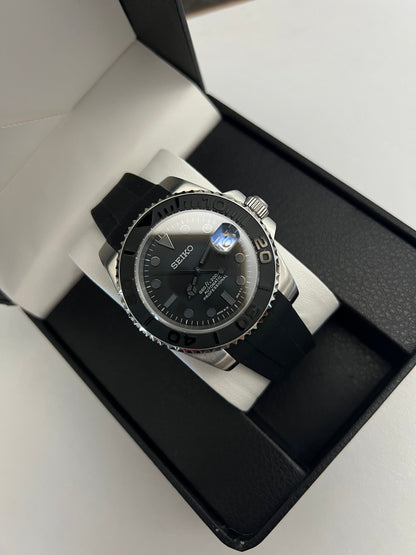 Yacht-Master (Grey) Seiko NH35 automatic mod watch. A full watch with a black dial and bezel on a black rubber strap inside a watch box.