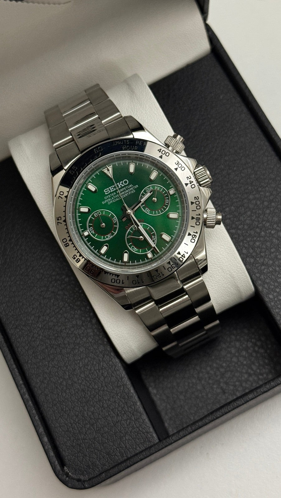 Daytona (Green) Seiko VK63 meca-quartz chronograph mod watch. A green dial watch with a silver bezel and metal link bracelet inside an open black display box.