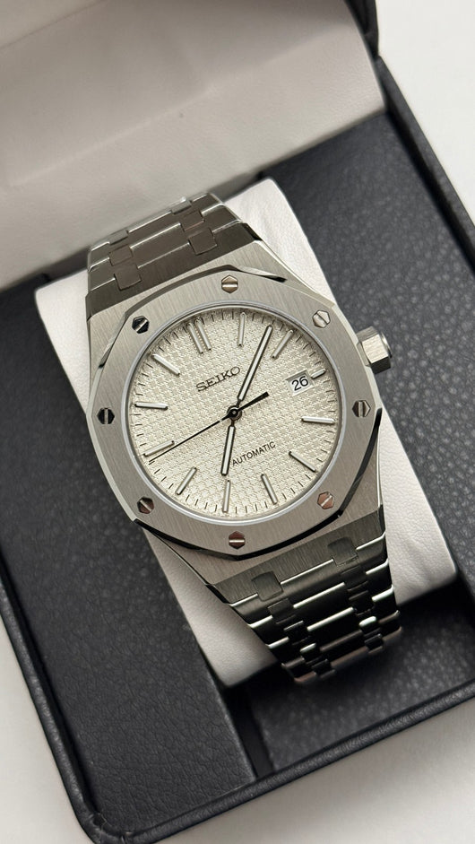 Royal Oak (White) Seiko NH35 automatic mod watch. A silver dial watch with a silver bezel and integrated metal bracelet shown in a full angled shot.