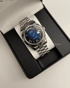 Day-Date (Blue Roman) Japanese automatic mod watch. A watch in a box with a blue dial and silver fluted bezel on a silver metal bracelet.