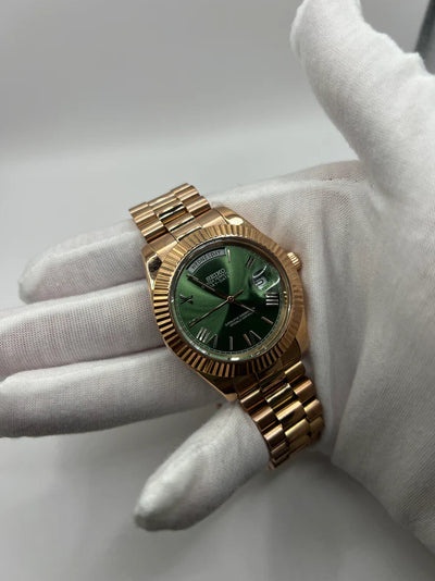 Day-Date (Rose Gold, Green) Japanese automatic mod watch. A wrist shot shows a gloved hand holding the rose gold watch with a green dial and metal link bracelet.