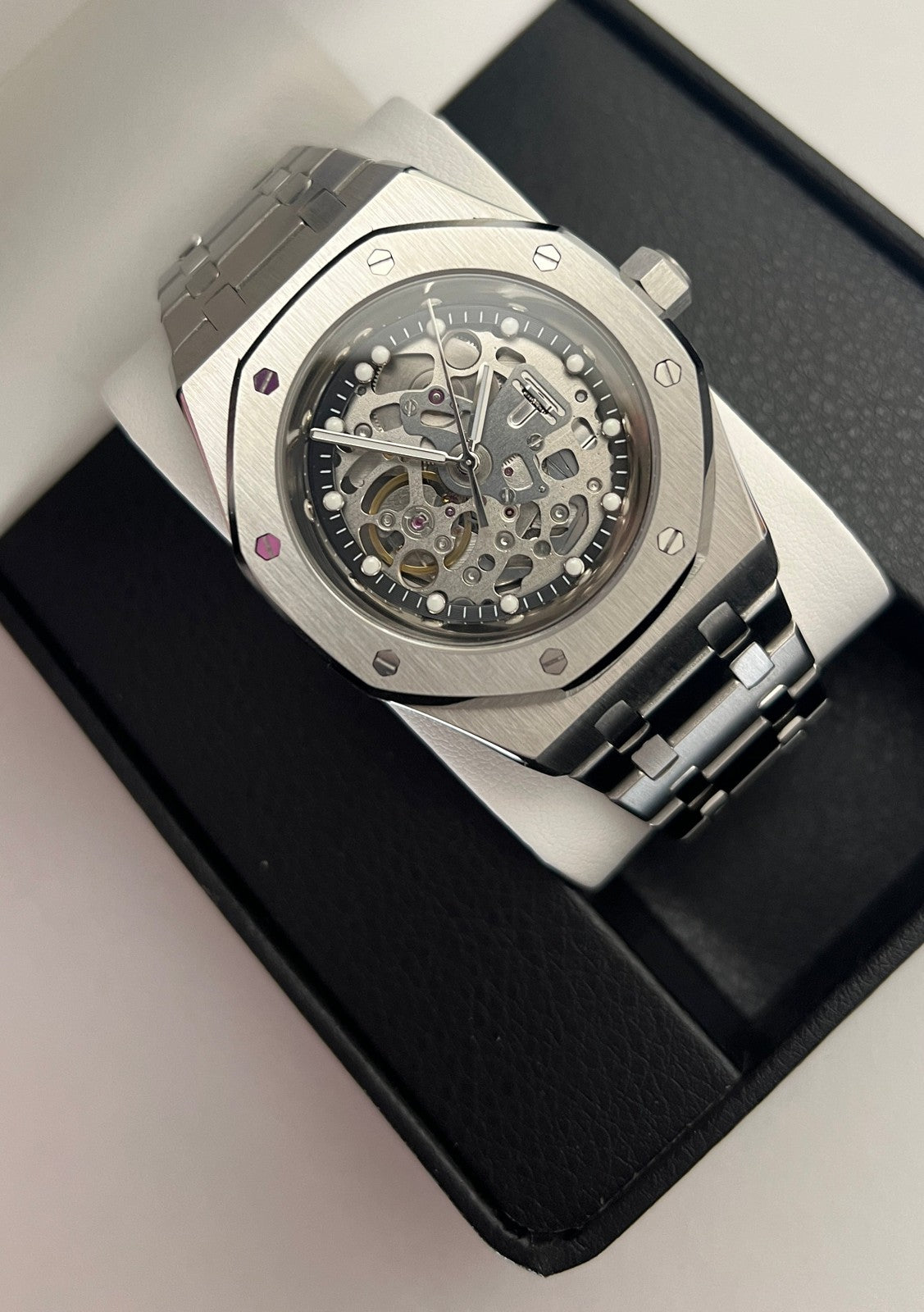 Royal Oak (Skeleton) Seiko NH70 skeleton automatic mod watch. A full watch shot shows a silver skeleton dial with a silver bezel and a silver metal link bracelet.