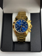 Daytona (Blue Gold) Seiko VK63 meca-quartz chronograph mod watch. A gold tone chronograph watch with a blue dial and gold bezel is shown in a straight on full shot.
