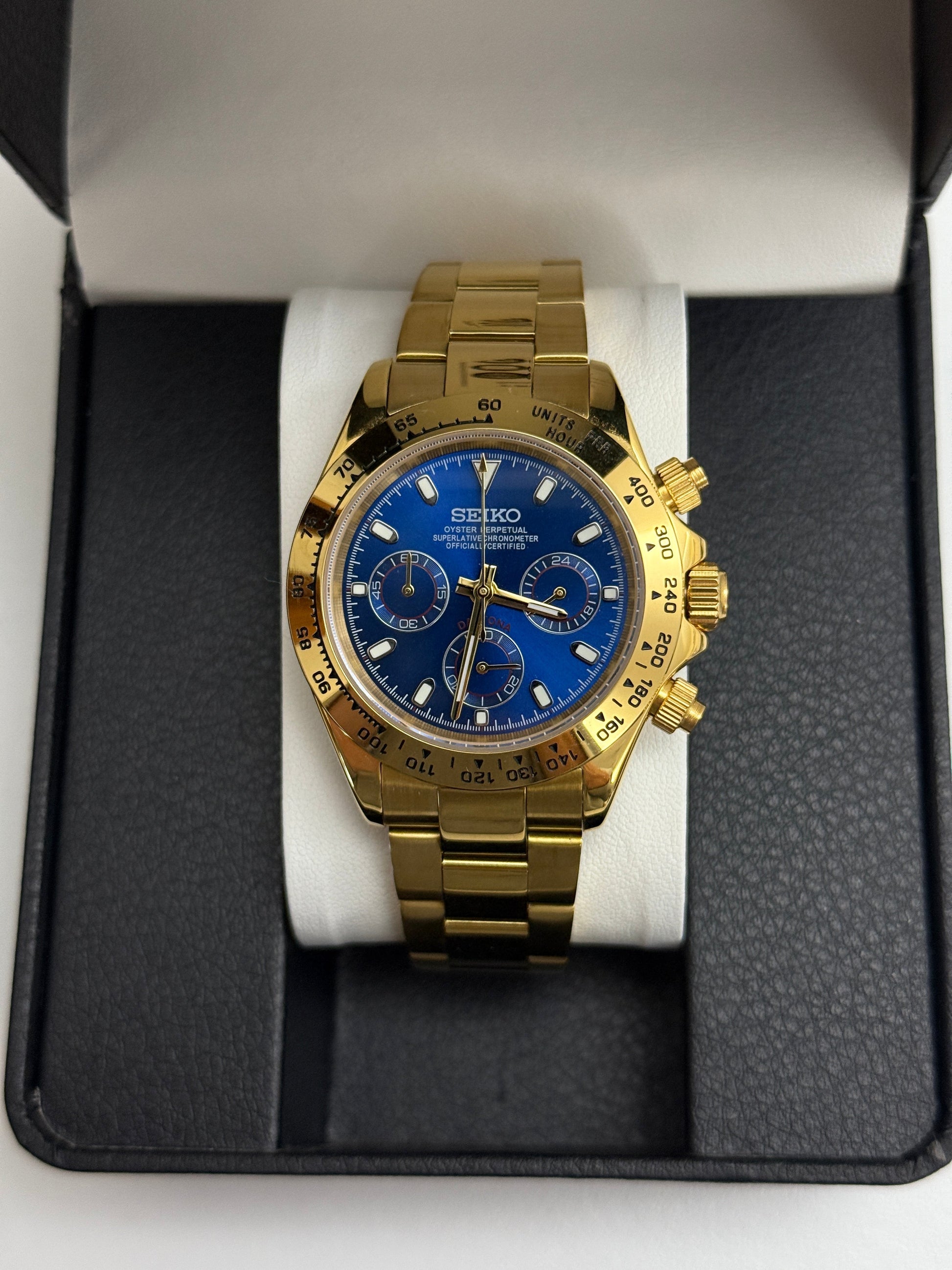 Daytona (Blue Gold) Seiko VK63 meca-quartz chronograph mod watch. A gold tone chronograph watch with a blue dial and gold bezel is shown in a straight on full shot.