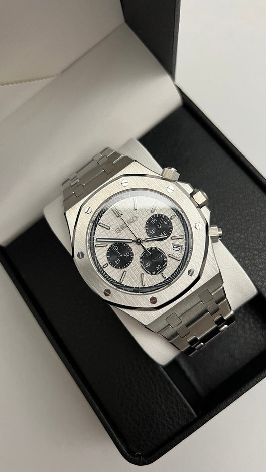 Royal Oak Chrono (Panda) Seiko VK63 meca-quartz chronograph mod watch. A high angle shot of a watch with a white dial and black subdials inside a black display box.