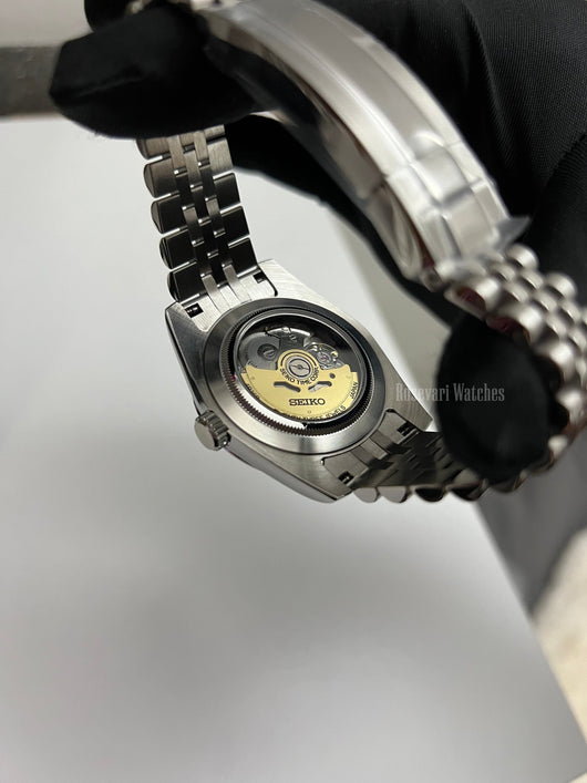 Datejust (Arabic Blue) Seiko NH35 automatic mod watch. A caseback detail shot showing the internal mechanical movement of the watch with a metal link bracelet.