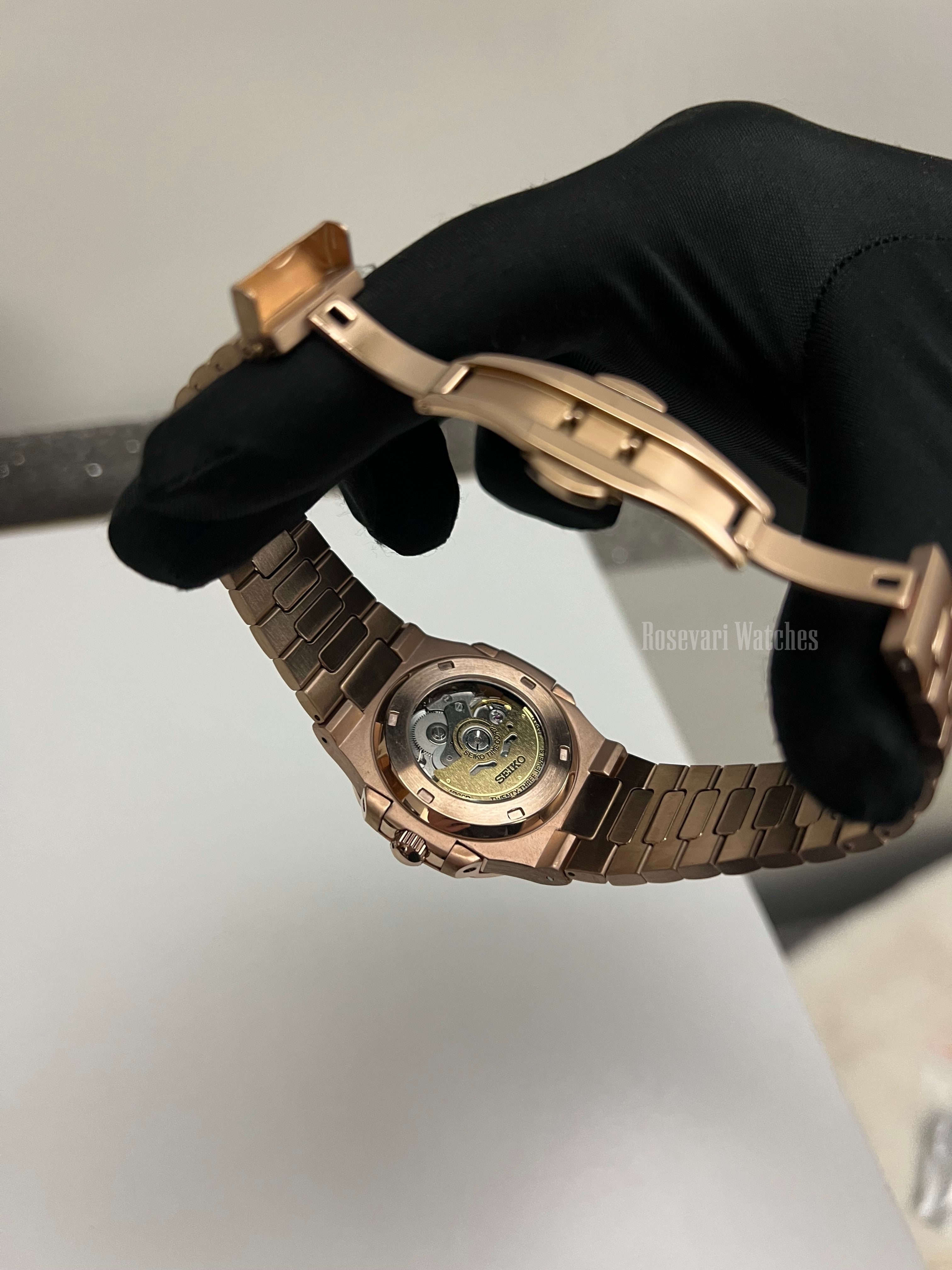 Nautilus (Open Heart, Chocolate) Seiko NH38 open-heart automatic mod watch. A caseback detail shot showing the mechanical movement and the rose gold bracelet clasp.
