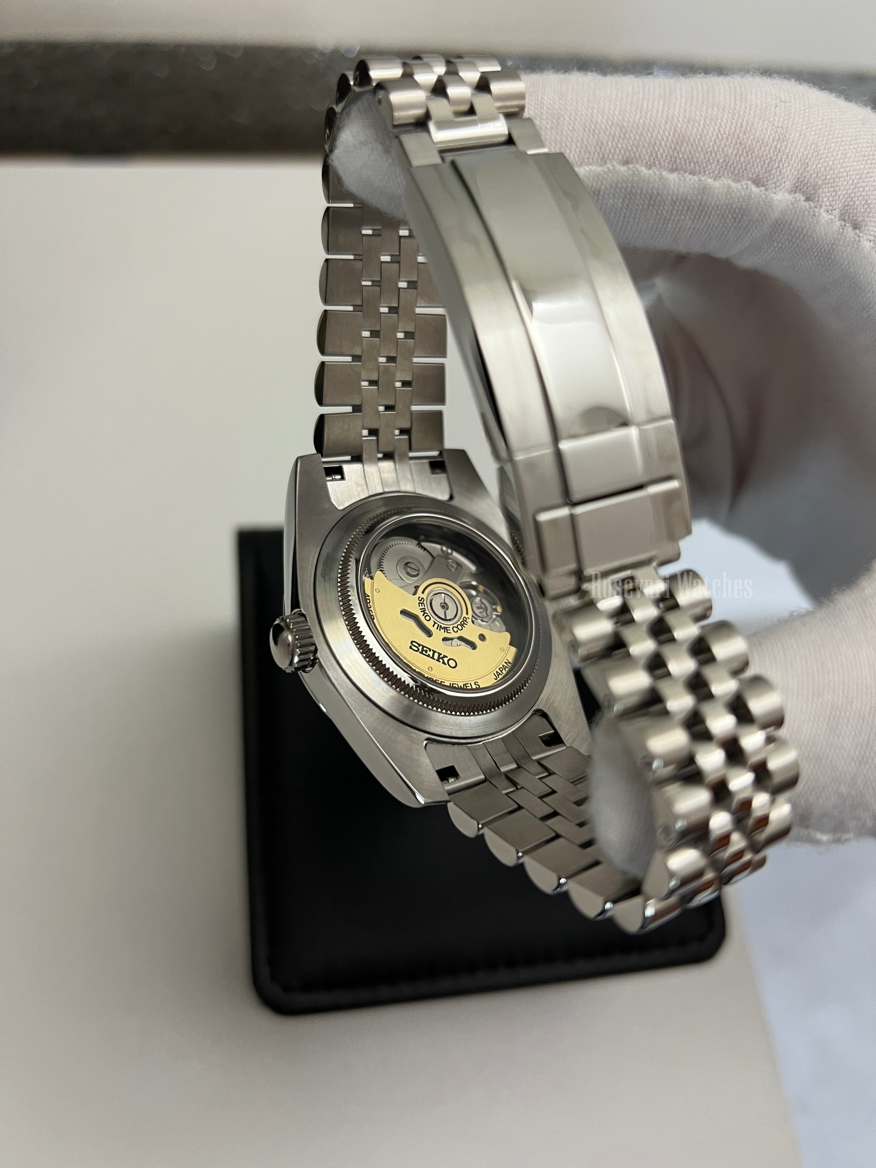 Datejust (Black Roman) Seiko NH35 automatic mod watch. A view of the watch caseback showing the mechanical movement and the jubilee bracelet in a side shot.