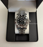 GMT (Bruce Wayne) Seiko NH34 GMT automatic mod watch. A full watch shot of a black dial watch with a black bezel inside a black presentation box.
