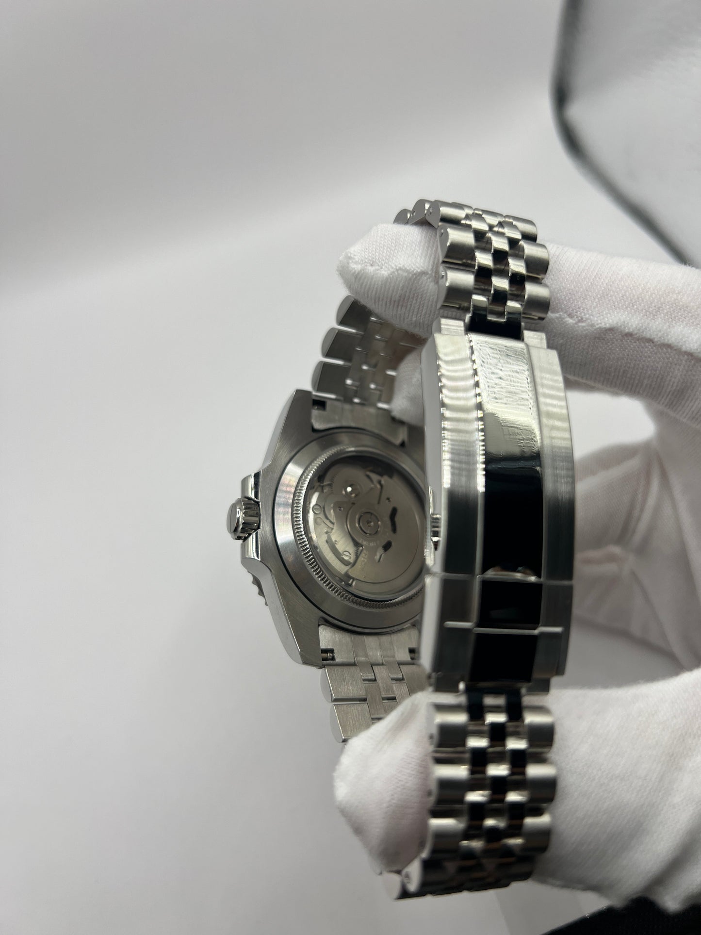 GMT (Pepsi) Seiko NH34 GMT automatic mod watch. A caseback and clasp detail shows the back of a watch case and a silver metal bracelet clasp.