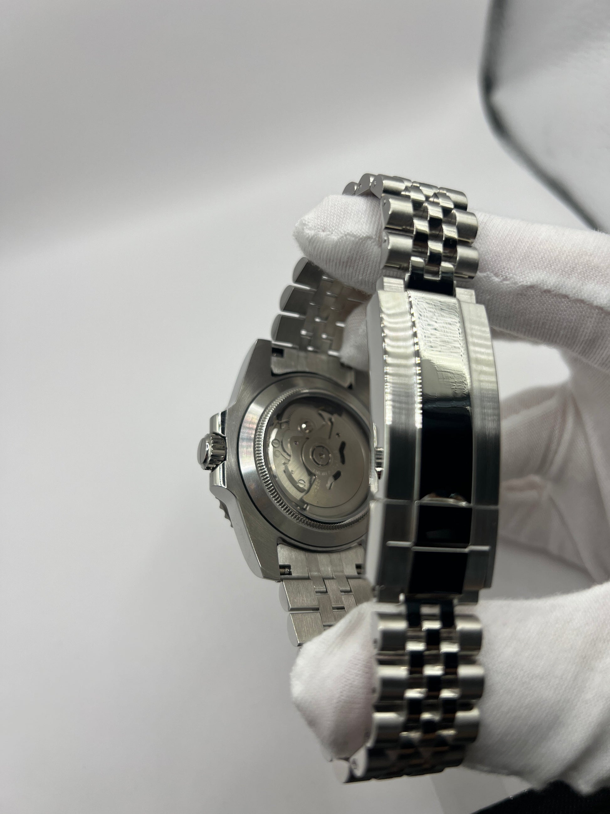 GMT (Pepsi) Seiko NH34 GMT automatic mod watch. A caseback and clasp detail shows the back of a watch case and a silver metal bracelet clasp.