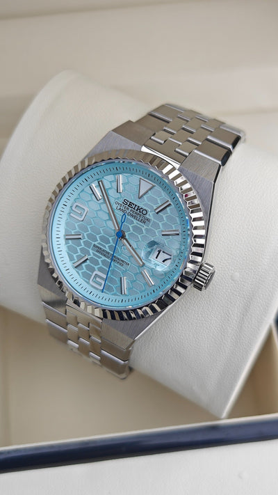 Land-Dweller (Tiffany) Seiko NH35 automatic mod watch. A light blue honeycomb dial watch with a silver fluted bezel and jubilee bracelet in a full view.