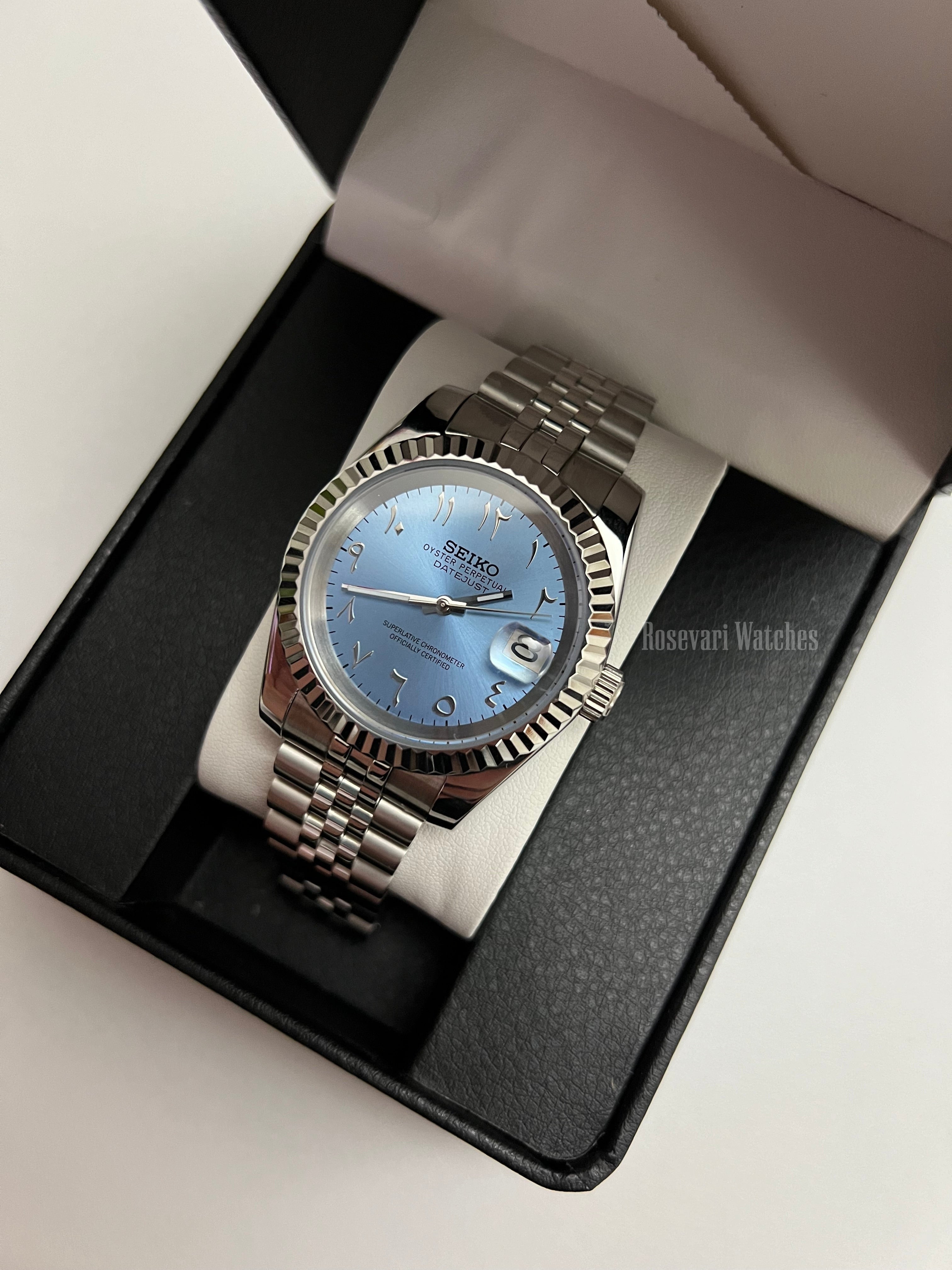 Datejust (Arabic Blue) Seiko NH35 automatic mod watch. A full watch shot inside a black box featuring a light blue dial and silver fluted bezel on a metal band.