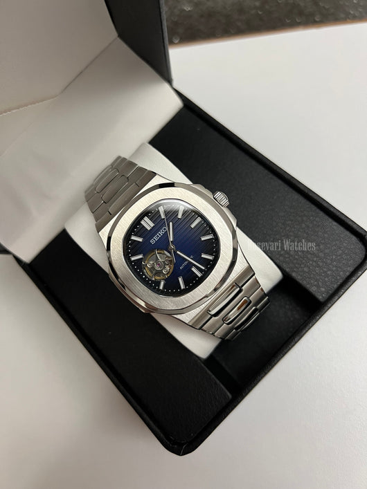 Nautilus (Open Heart, Royal Blue) Seiko NH38 open-heart automatic mod watch. A full watch shot in a box showing a blue dial and silver bezel with a metal link bracelet.