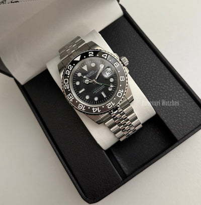 GMT (Bruce Wayne) Seiko NH34 GMT automatic mod watch. A full watch shot of a black dial watch with a grey and black bezel inside a black presentation box.