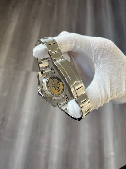 GMT (Coke) Seiko NH34 GMT automatic mod watch. A view of the watch caseback showing the internal movement mechanism held by a gloved hand.