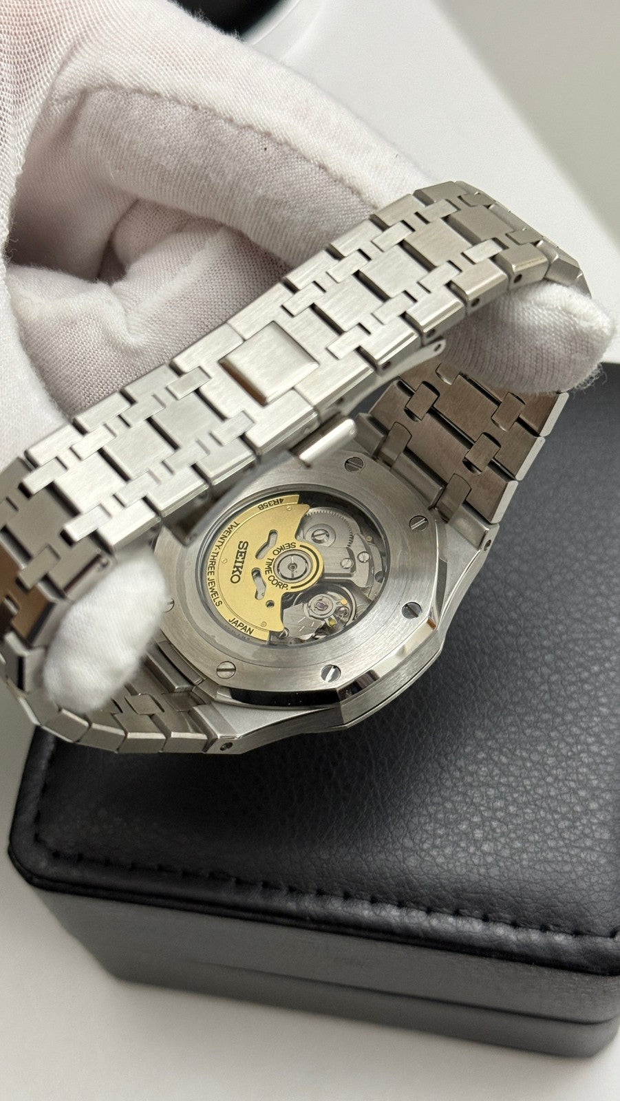 Royal Oak (White) Seiko NH35 automatic mod watch. The caseback of a silver watch showing the internal mechanical movement and metal bracelet.