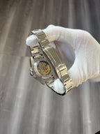 Submariner (Kermit) Seiko NH35 automatic mod watch. A close up view of the watch caseback showing the internal movement mechanism held by a gloved hand.