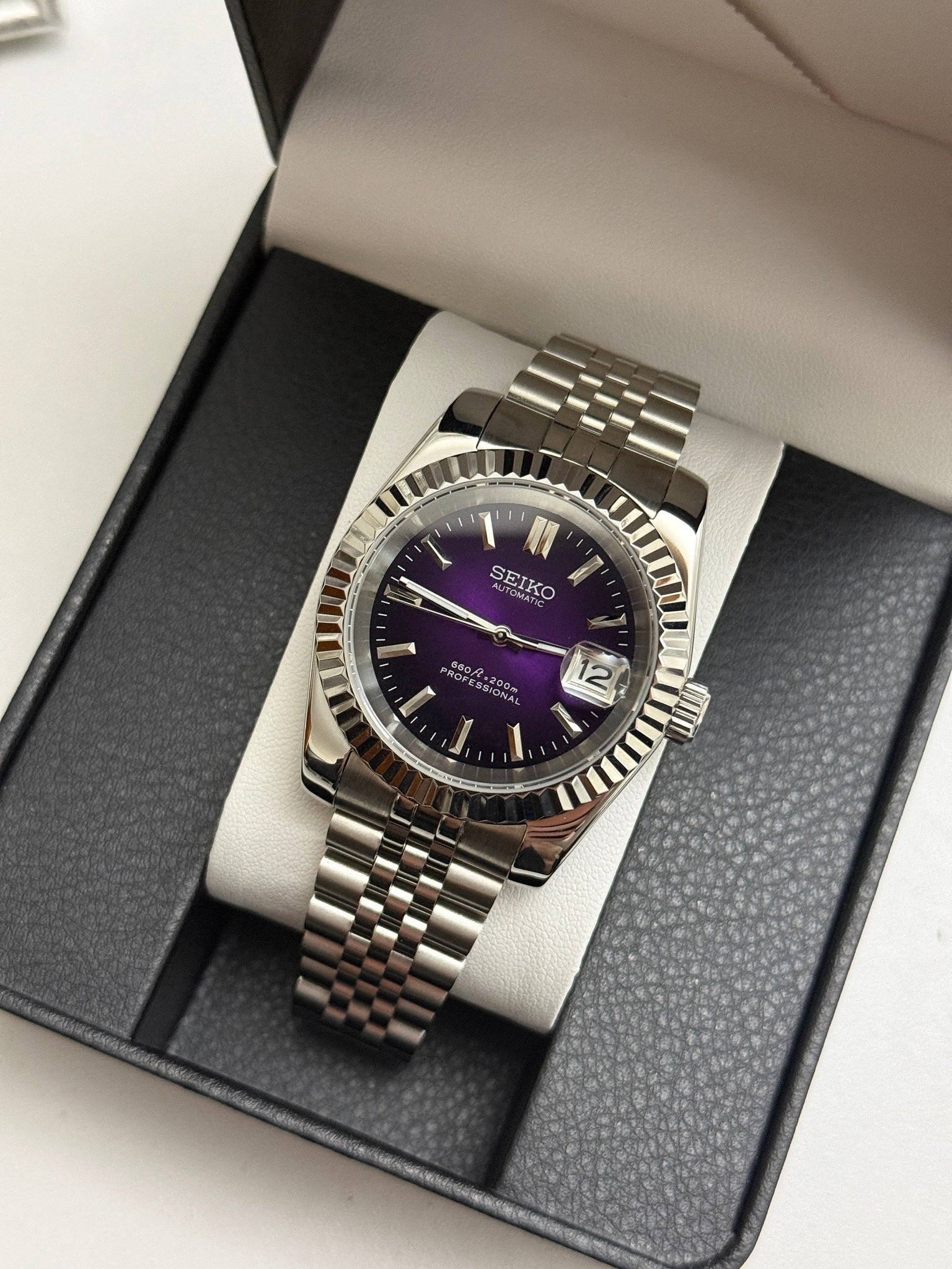 Datejust (Purple) Seiko NH35 automatic mod watch. A full watch shot inside a box displaying a purple dial with a silver fluted bezel and silver bracelet.