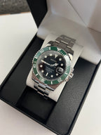 Submariner (Kermit) Seiko NH35 automatic mod watch. A full watch with a black dial and green bezel on a metal link bracelet inside an open watch box.