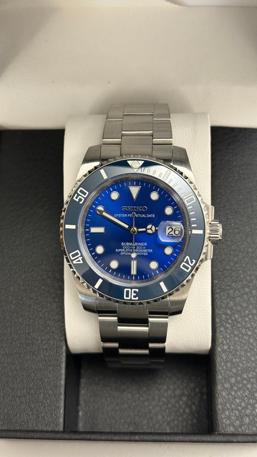 Submariner (Blue) Seiko NH35 automatic mod watch. A front view of a blue dial and blue bezel watch with a silver metal link bracelet in a box.