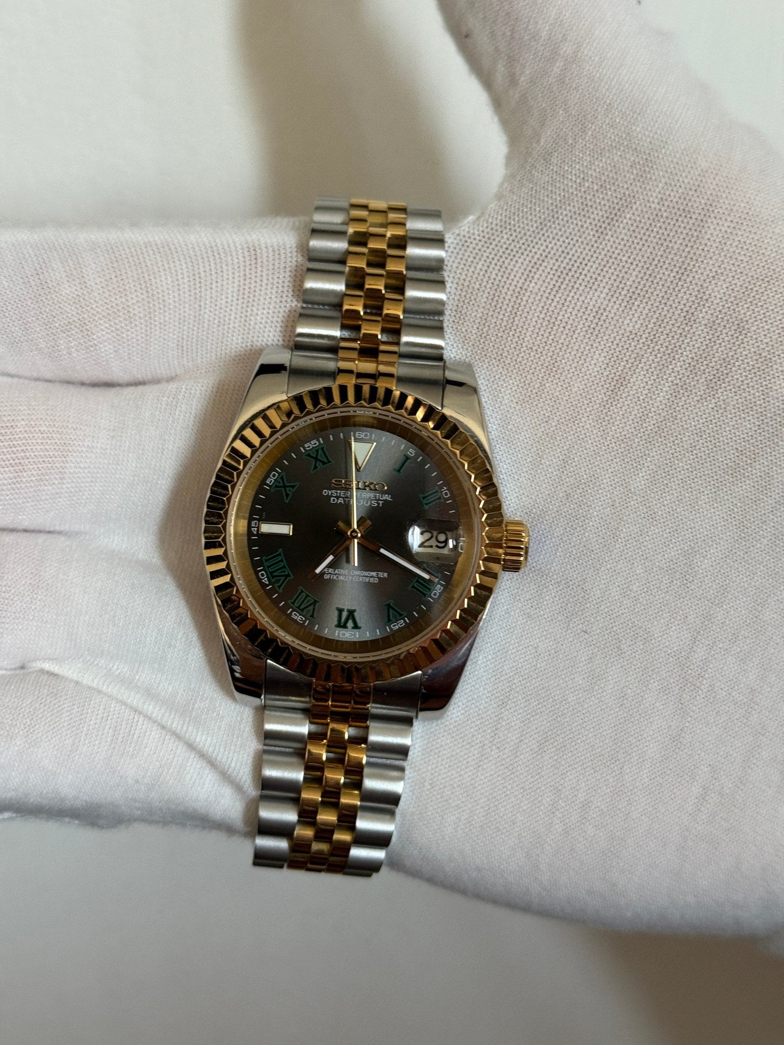 Datejust (Wimbledon Two-Tone) Seiko NH35 automatic mod watch. A hand in a white glove holds the watch showing the dark grey dial and gold fluted bezel on a two tone bracelet.