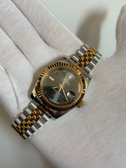 Datejust (Wimbledon Two-Tone) Seiko NH35 automatic mod watch. A hand in a white glove holds the watch showing the dark grey dial and gold fluted bezel on a two tone bracelet.