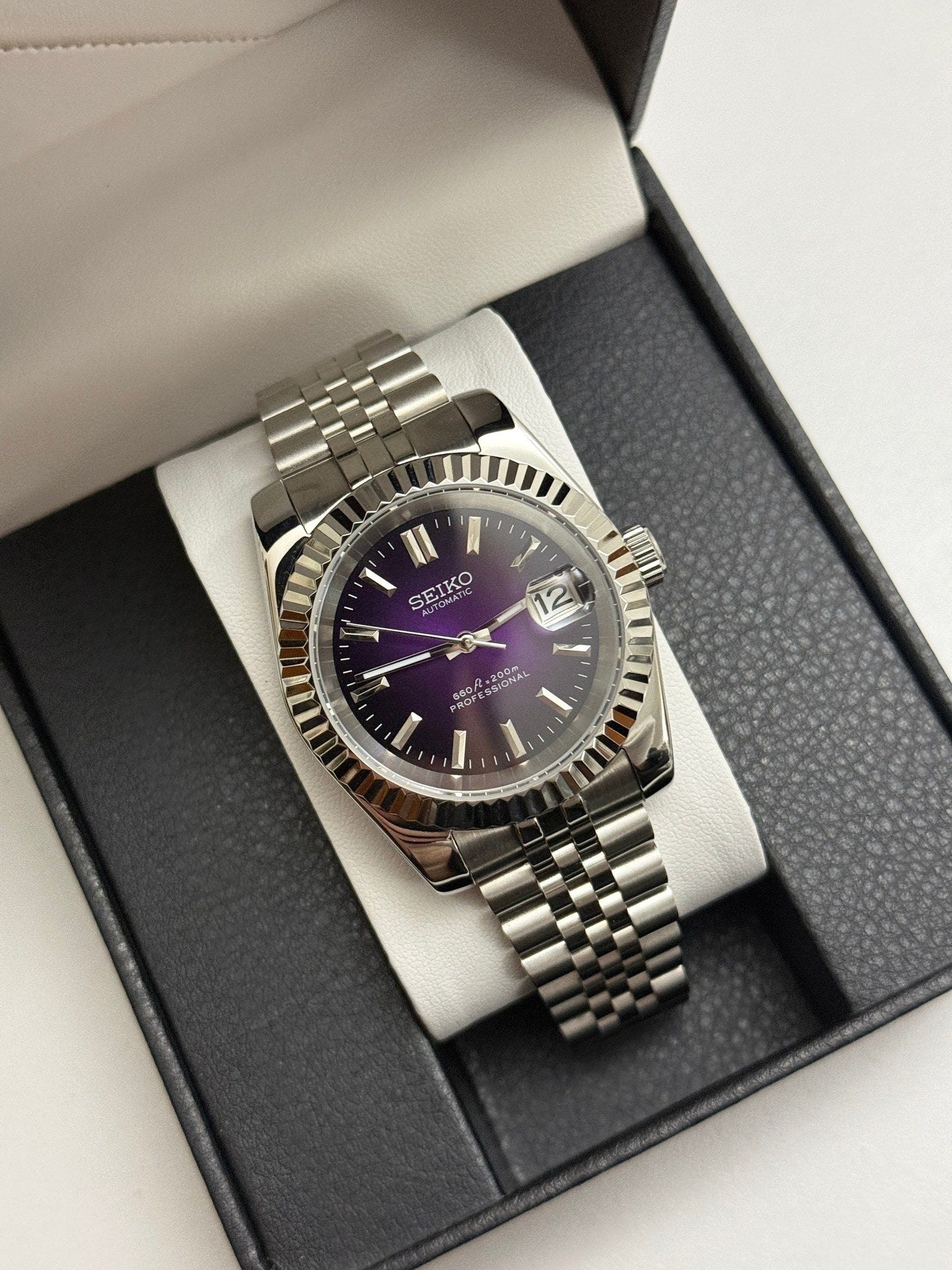 Datejust (Purple) Seiko NH35 automatic mod watch. A full watch shot inside a box featuring a purple dial with a silver fluted bezel and silver bracelet.