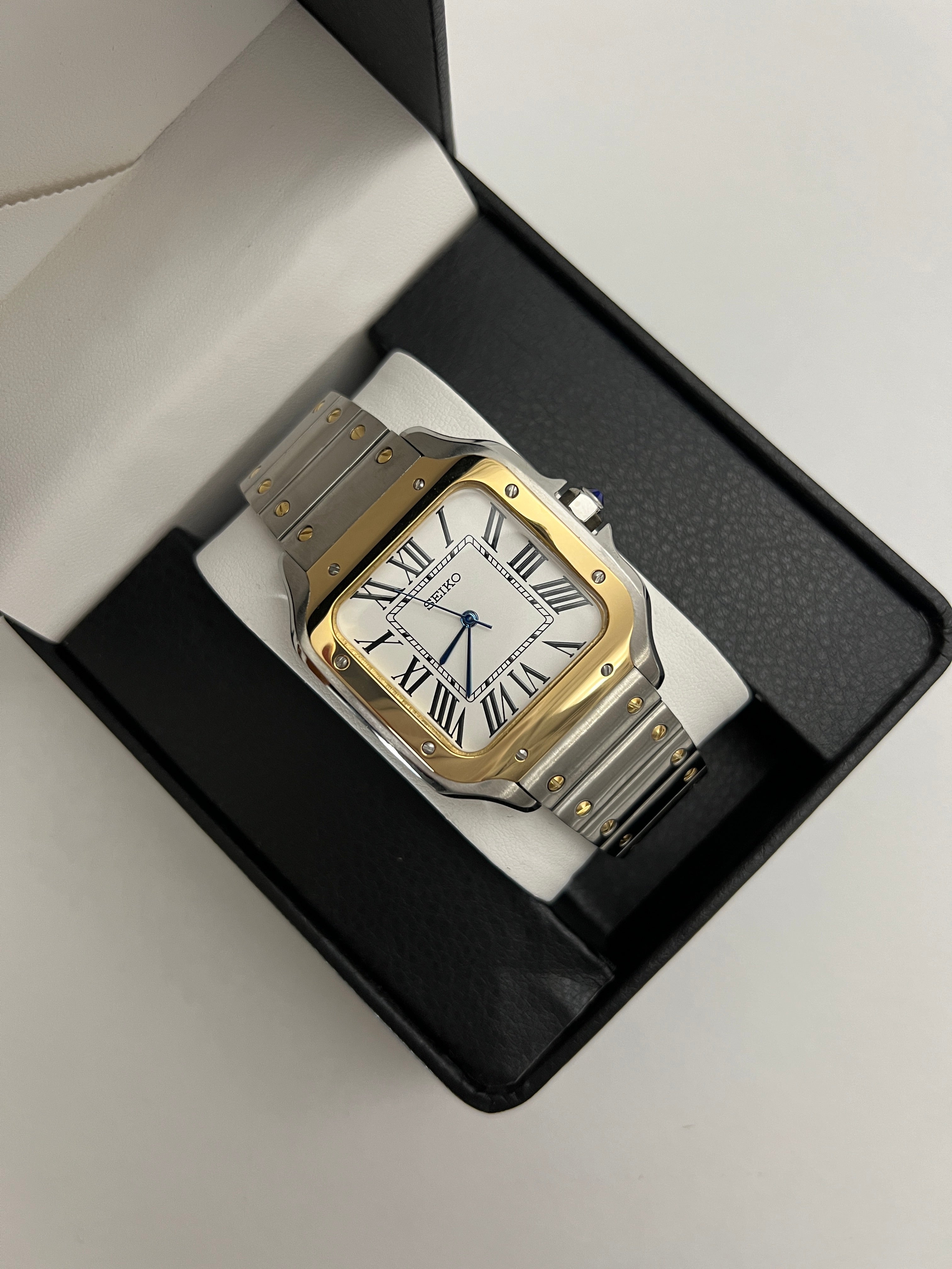 Santos (Two-Tone Gold) Seiko NH35 automatic mod watch. A watch in a box showing a white dial with a gold bezel and a silver and gold metal link bracelet.
