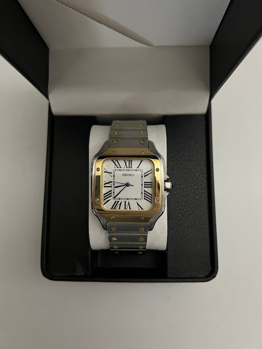 Santos (Two-Tone Gold) Seiko NH35 automatic mod watch. A watch in a box showing a white dial with a gold bezel and a silver and gold metal link bracelet.